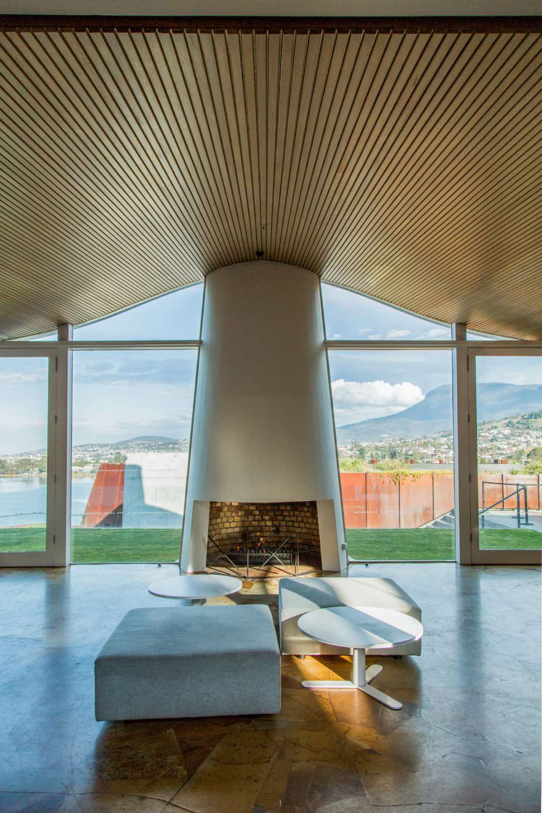 sala de estar con chimenea minimalista blanca y grandes ventanales