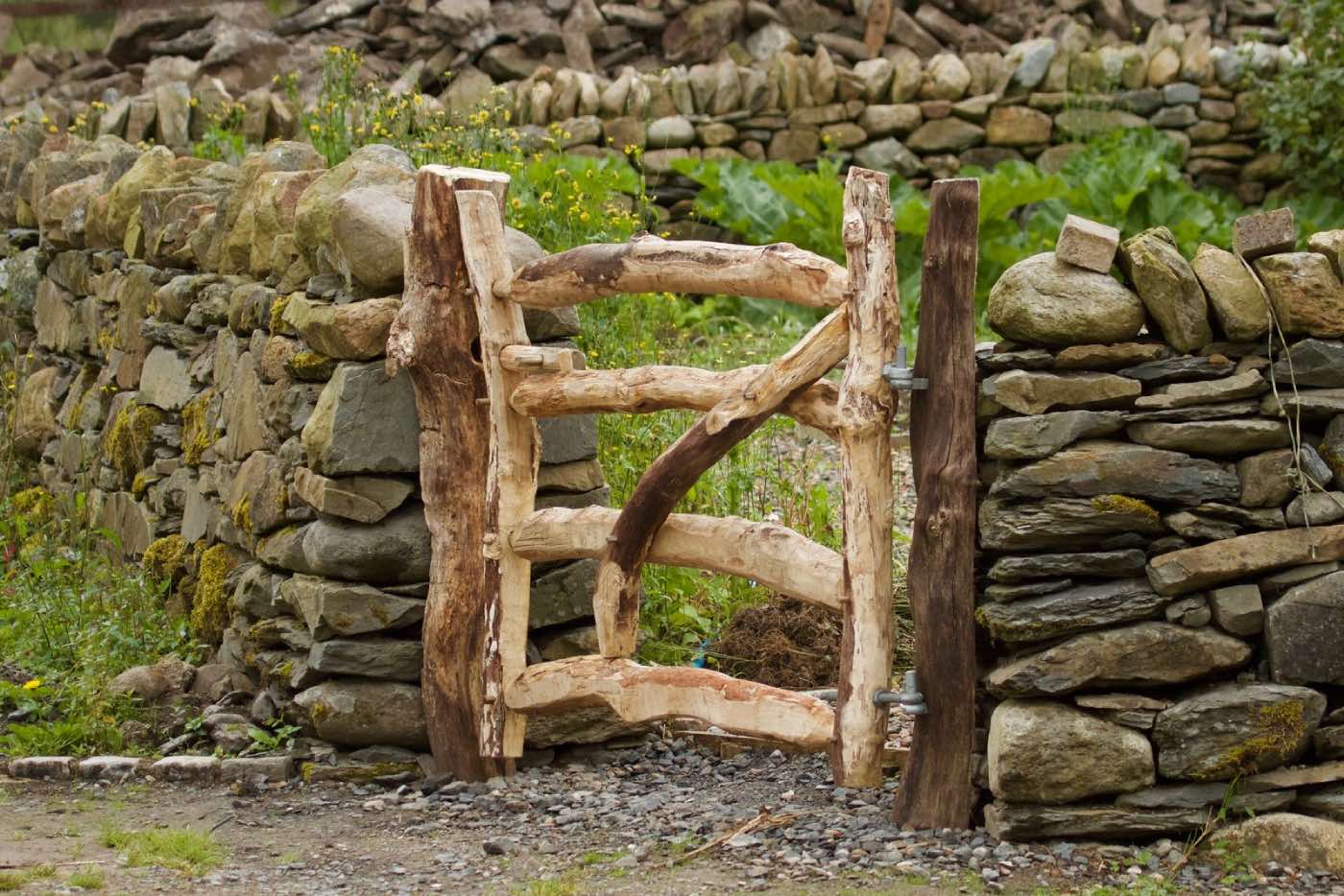 small rustic garden with stone wall and wood door