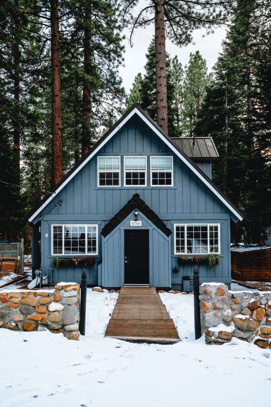 fachada de casa pequeña azul en el bosque