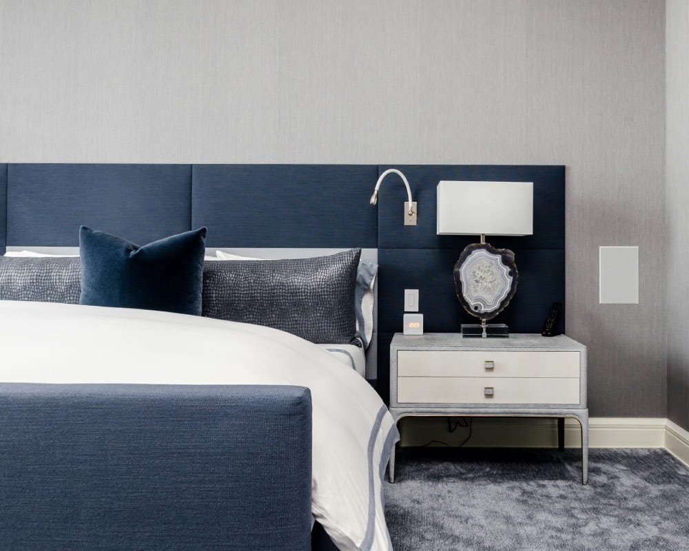 bedroom corner with deep blue bed and pillows