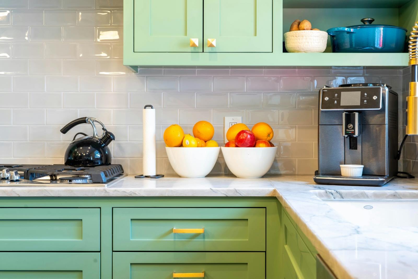 cocina verde con encimera de mármol y azulejos blancos