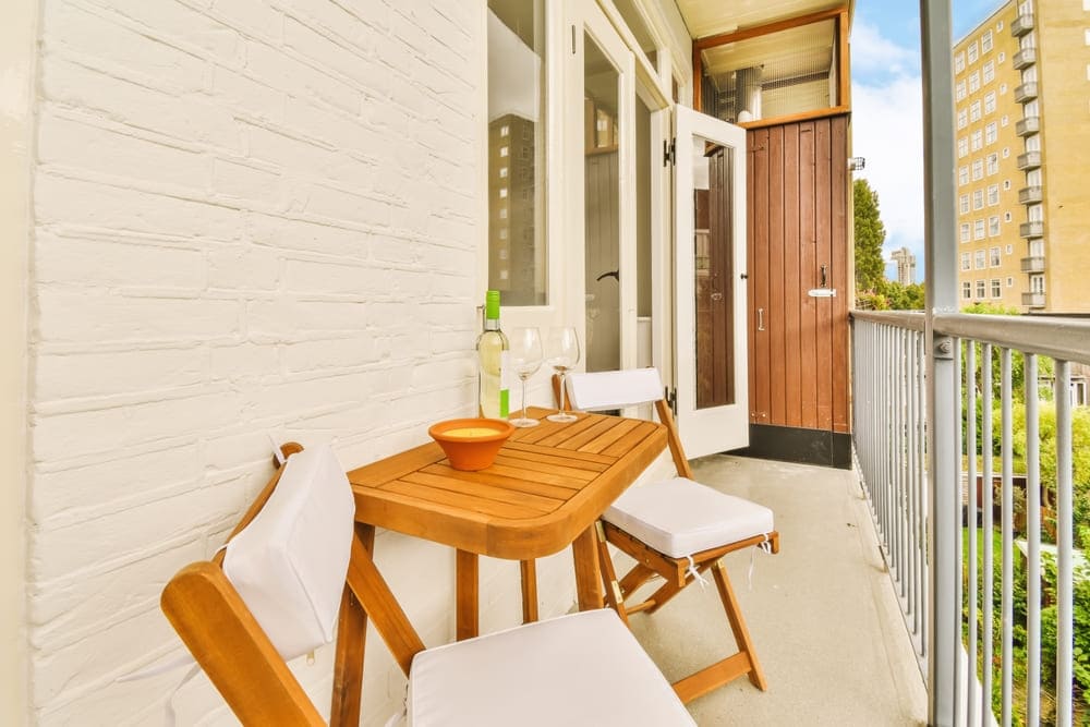 área externa pequena com mesa de madeira e dois bancos