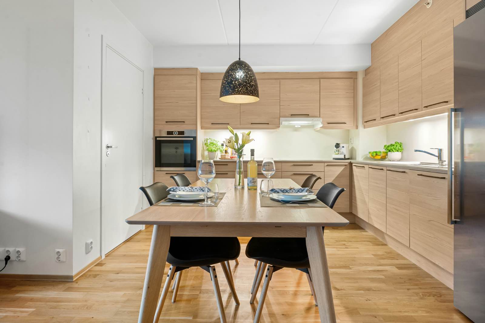 cocina blanca con muebles de madera clara, espacio cálido y acogedor
