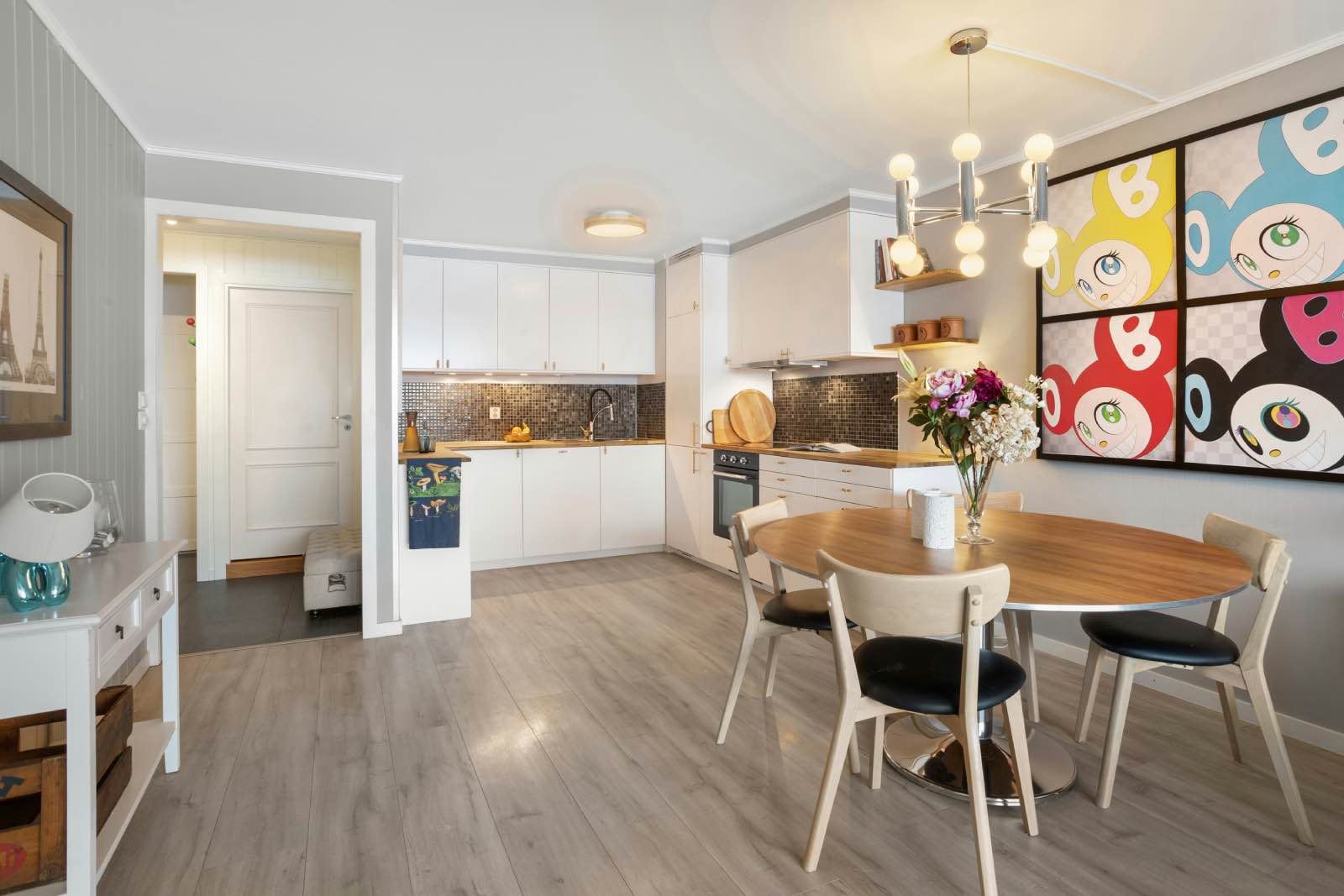 cocina blanca mate con madera brillante, comedor de madera y cuadro de colores