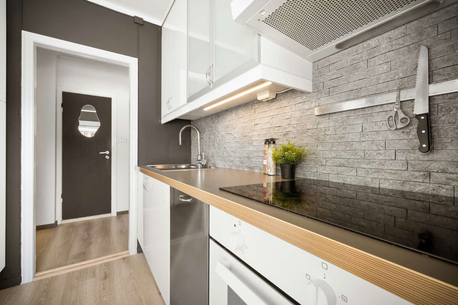 cocina con encimera de madera y muebles blancos