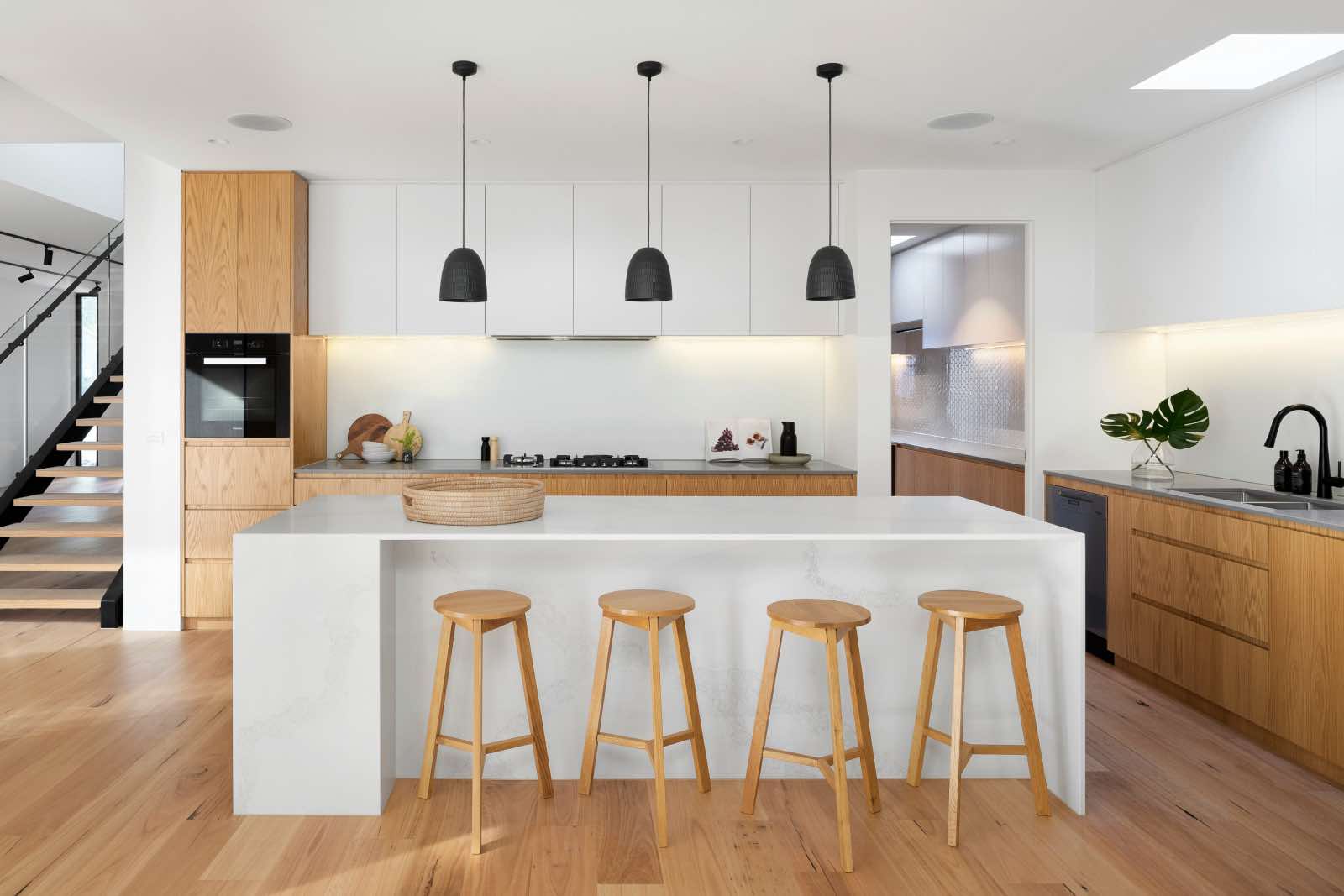 cocina contemporánea blanca con muebles y banquetas de madera