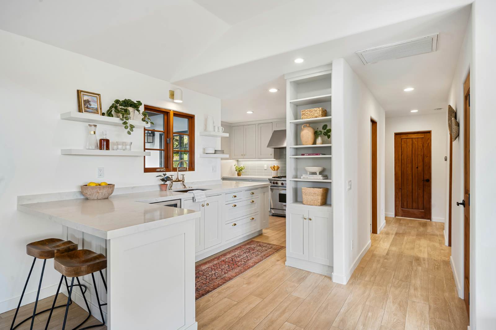 cocina de estilo mediterráneo con madera natural, blanco y barra de desayuno