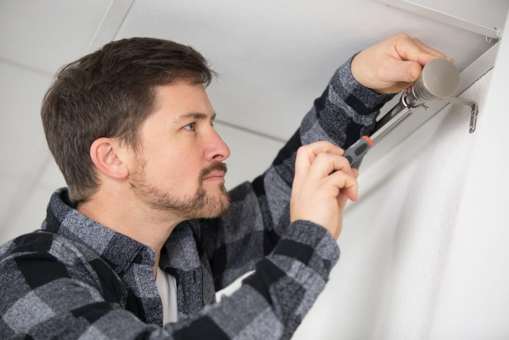 Mann zieht Vorhang an der Wand auf