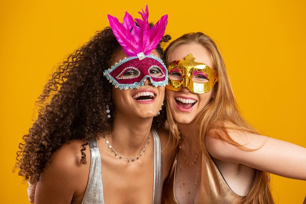 duas mulheres com máscaras de Carnaval