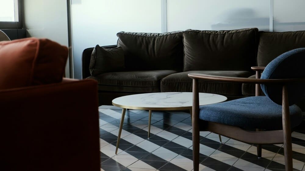 sala decorada com sofá preto e poltronas coloridas