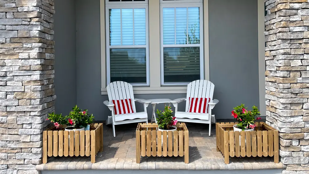 front porch with two chairs and planters