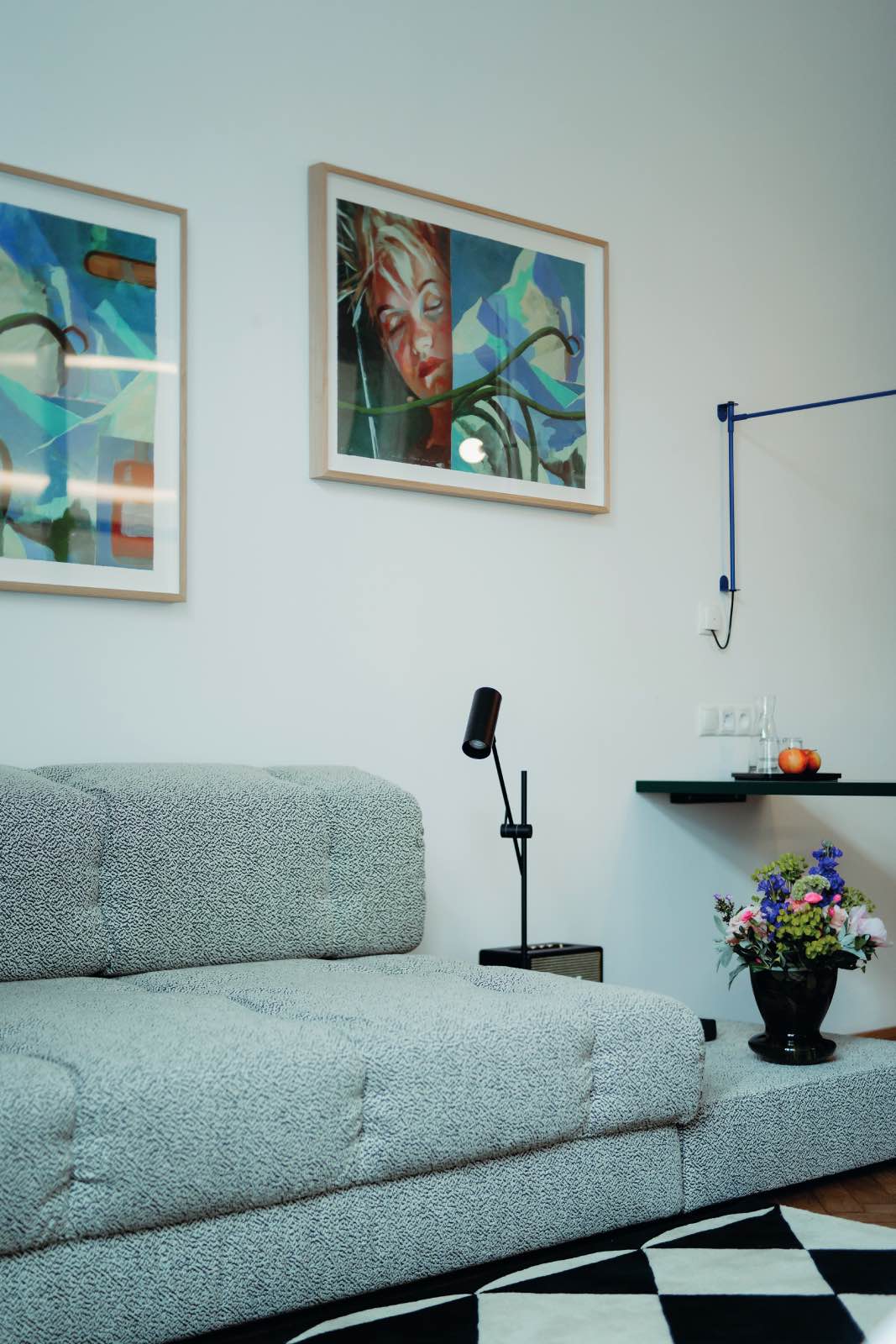 sofá tapizado y obras de arte en dormitorio moderno