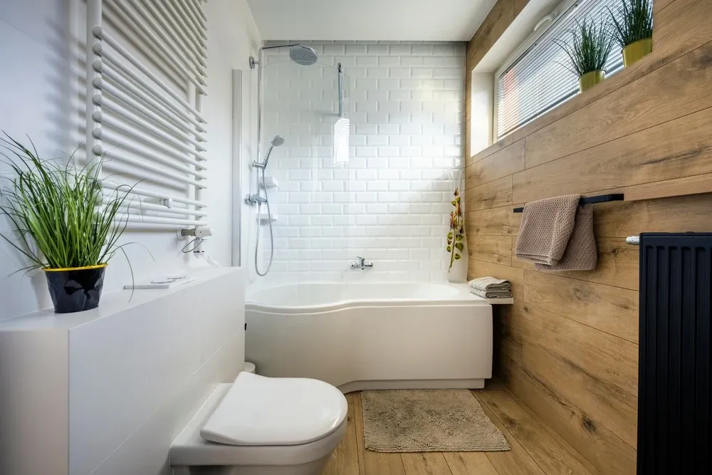 small bathroom with wooden-looking accent wall and plants