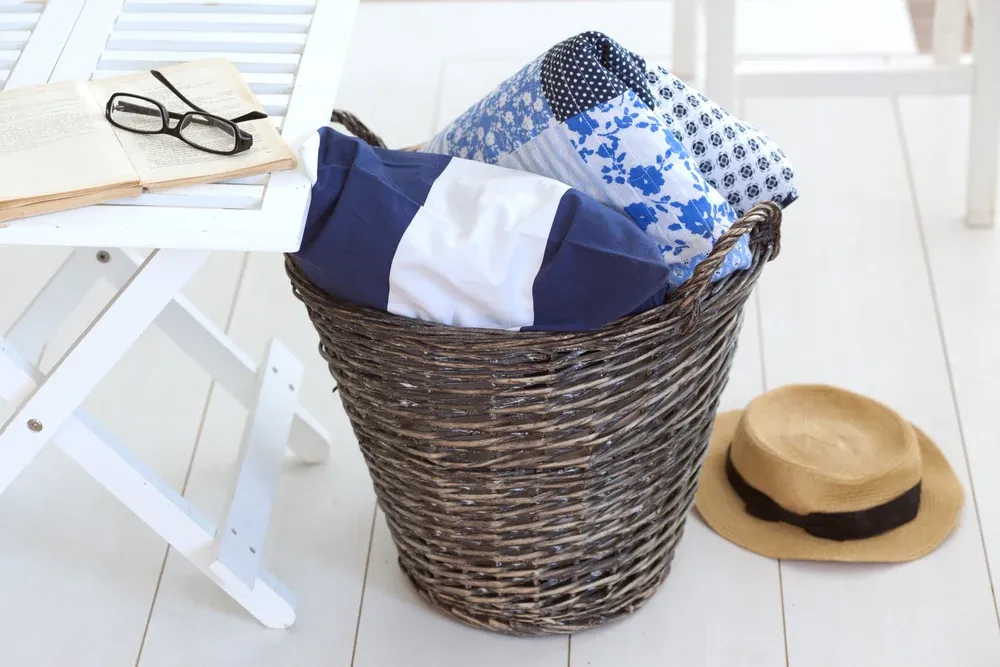 Wicker basket with patchwork quilt and a pillow