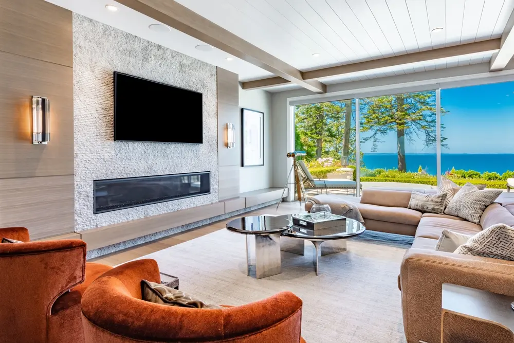 living room with orange chairs piano wooden beams and ocean view
