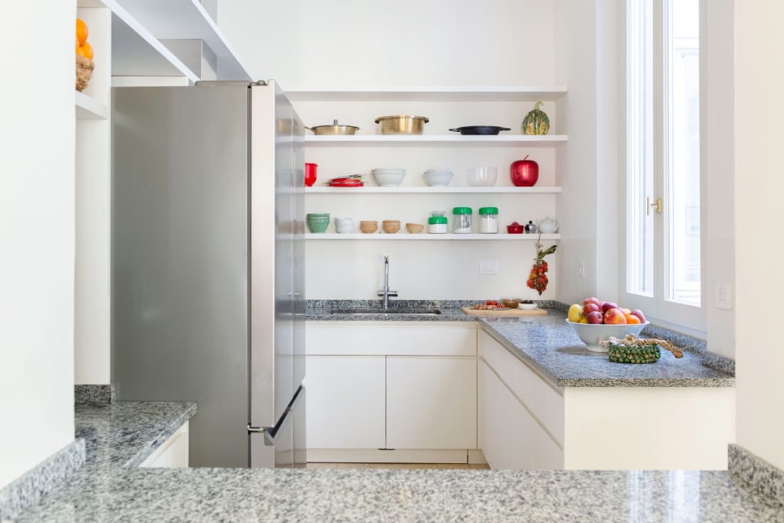 cocina moderna en apartamento reformado. Encimera granito, nevera inoxidable 