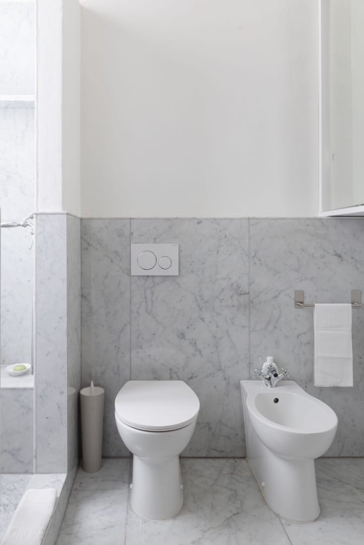 cuarto de baño blanco con mármol, casa reformada 