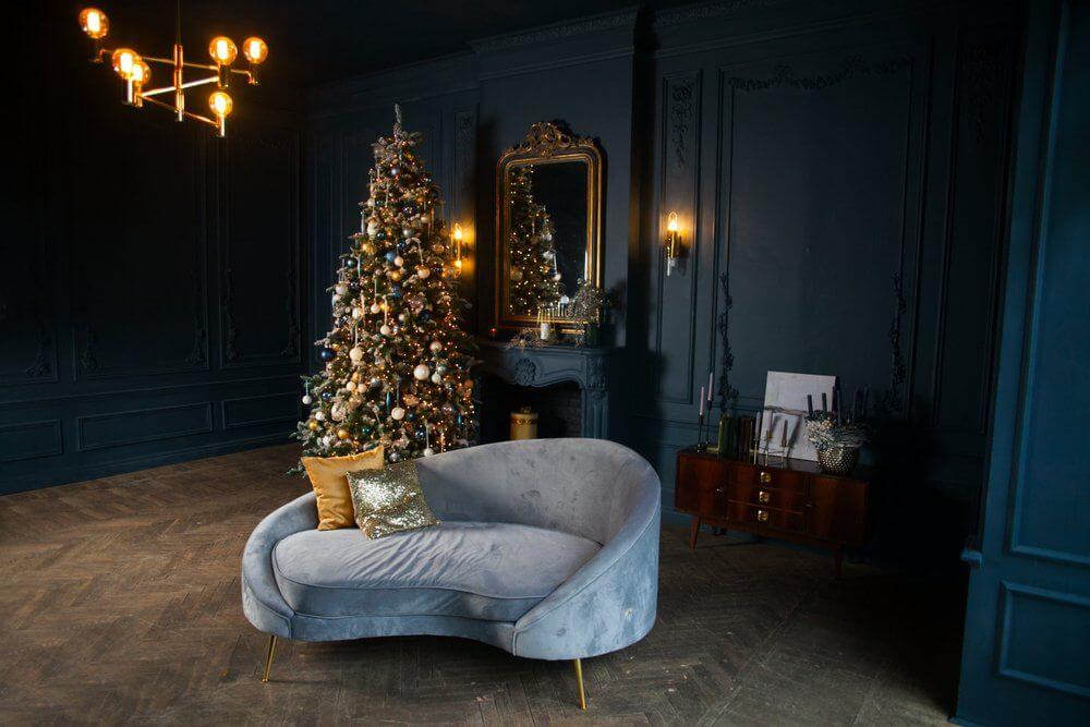 Holiday decorated room with fireplace,light blue sofa, and golden pillows