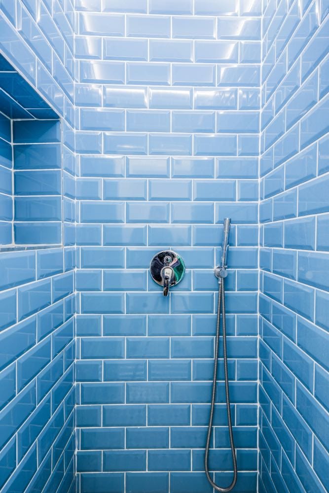 ducha de obra con azulejos azules en baño moderno de diseño