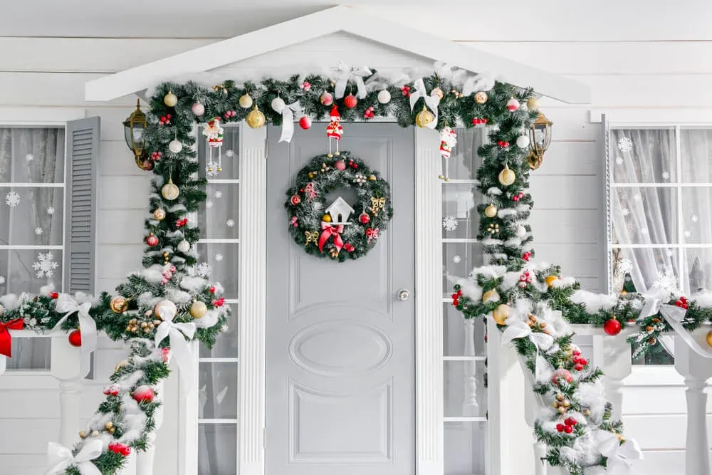 front door decorated with garlands and a wreath for christmas