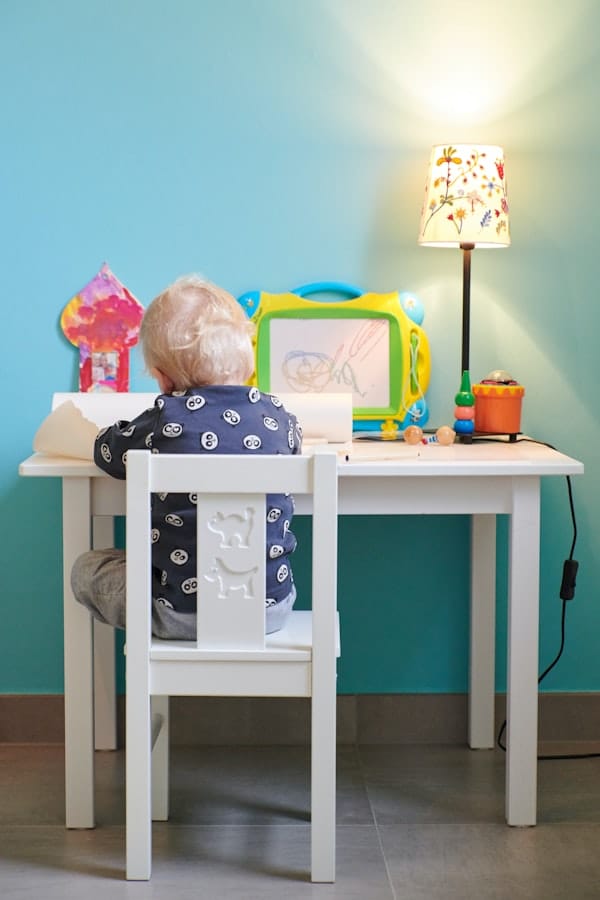 small boy drawing at his desk