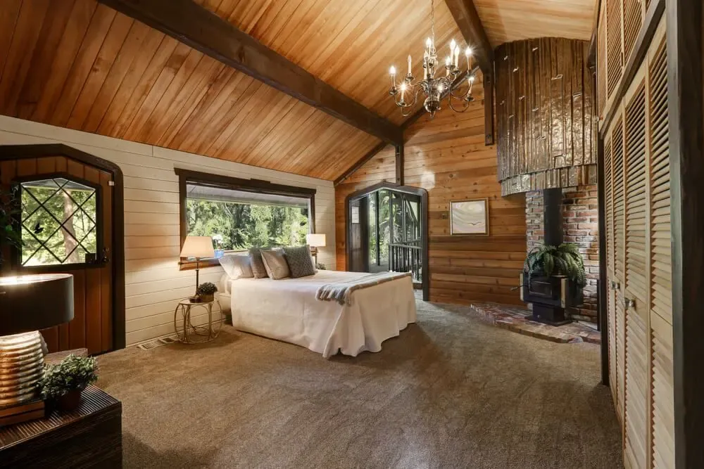Chambre en bois avec haut plafond voûté et cheminée