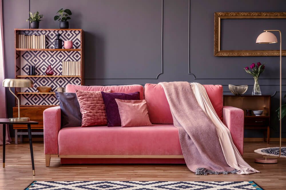 Pink sofa in a room with purple walls, learn how colors affect our mood