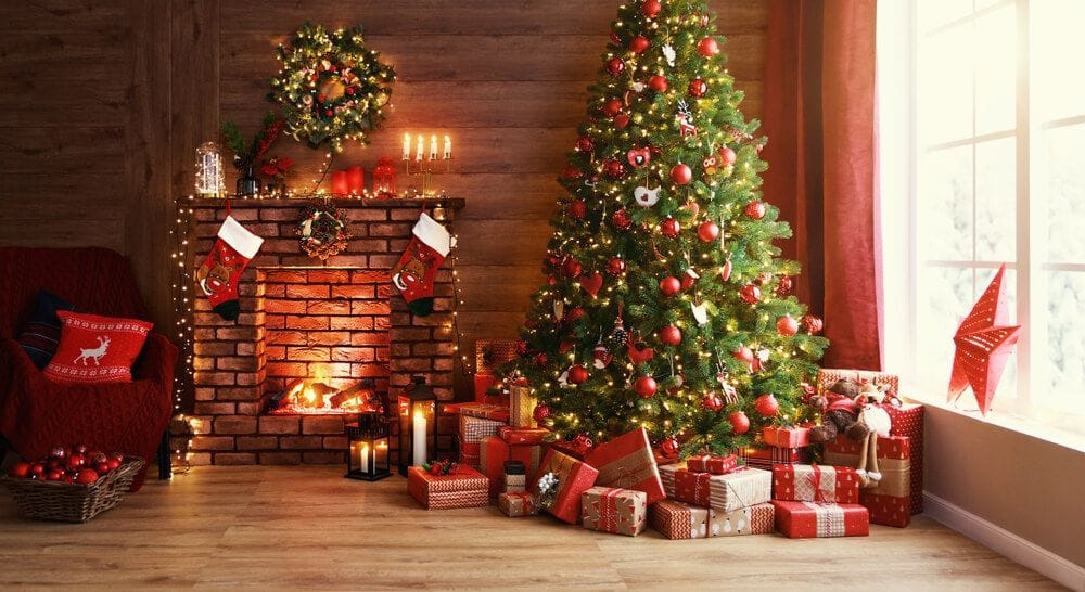 Weihnachtsbaum umgeben von verpackten Geschenken und einem Kamin