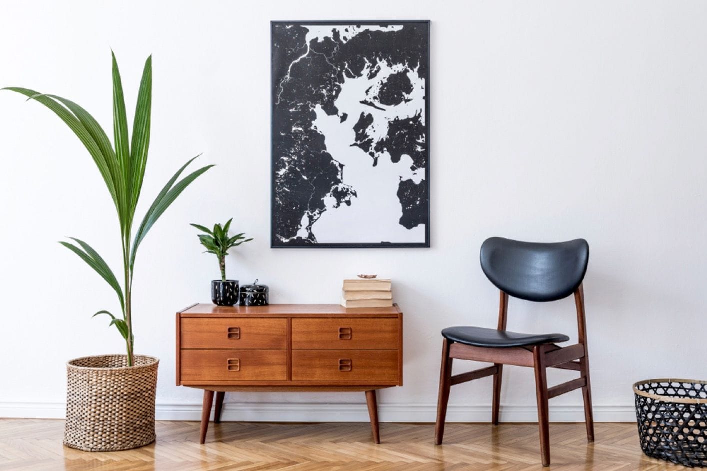 Salon avec meuble rétro en bois, chaise, plante tropicale dans un pot en rotin, panier