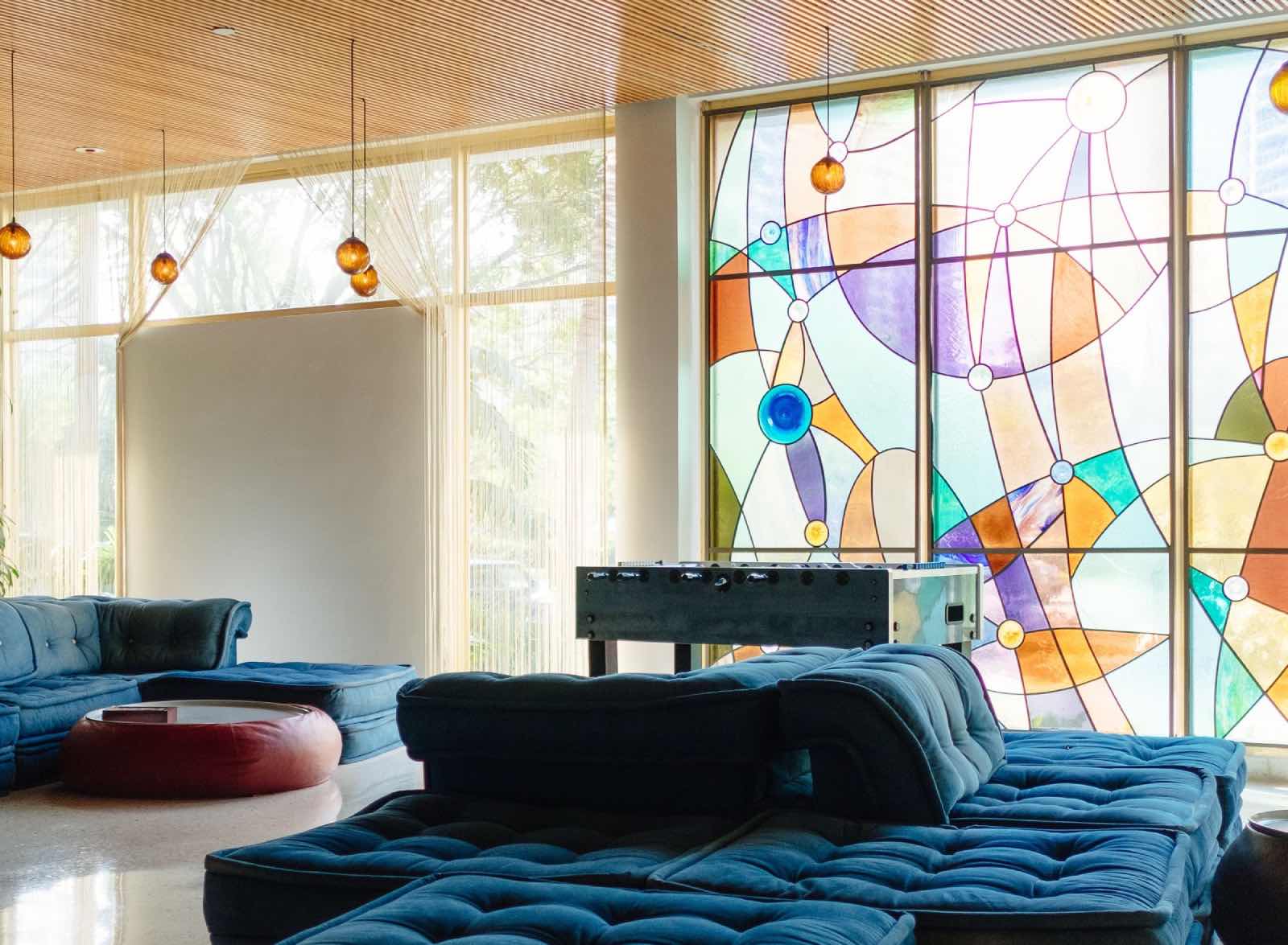 sala de estar con vidrieras de colores y sofás azules