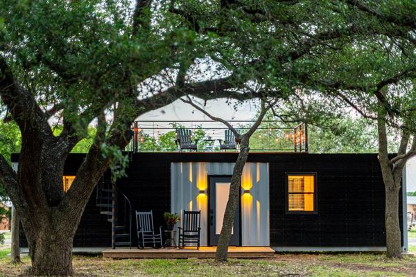 black shipping container home with a dec
