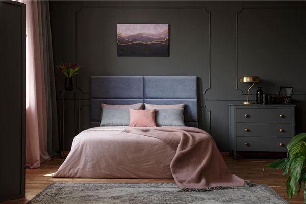 Dark and moody bedroom interior with pink accents