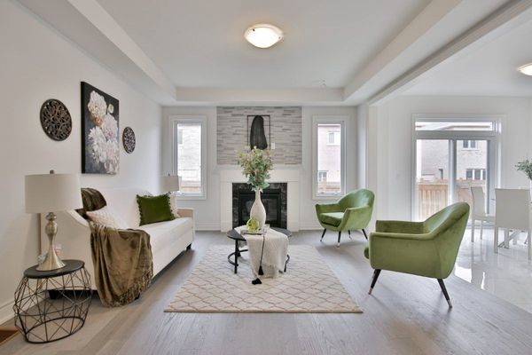 sala de estar amplia y luminosa con sillones verdes y sofá blanco: cómo evitar errores de decoración