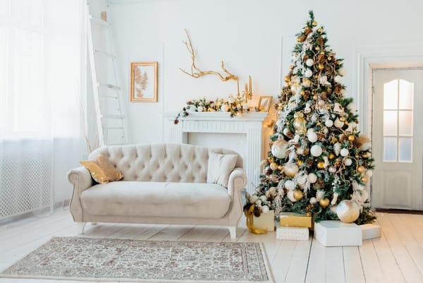 White Christmas room with a Christmas tree decorated with golden toys