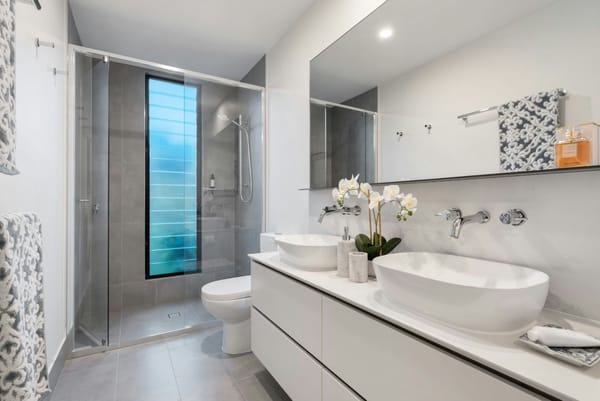 cuarto de baño pequeño moderno blanco con ducha y retrete y 2 lavabos