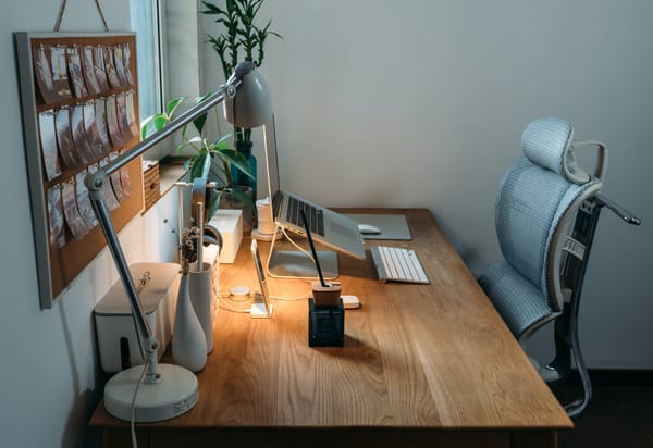 bureau à domicile avec une chaise ergonomique, un support pour ordinateur portable et des plantes sur un bureau en bois