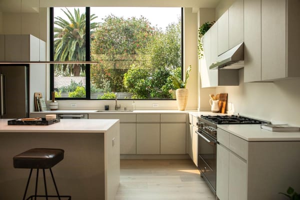 cocina moderna blanca con ventanales, tendencias que dejar atrás en 2024