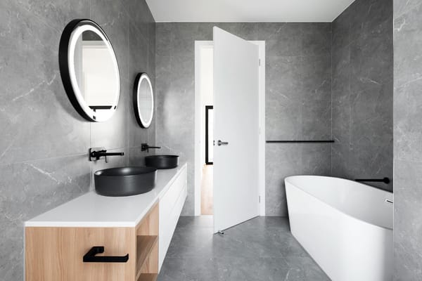 cuarto de baño blanco y negro con paredes de mármol gris y grifos negros