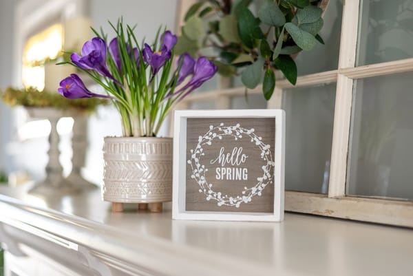 Panneau Hello spring avec des fleurs violettes sur la cheminée - idées de décoration pour le printemps