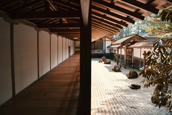 jardín zen japonés con arena y rocas y un porche de madera