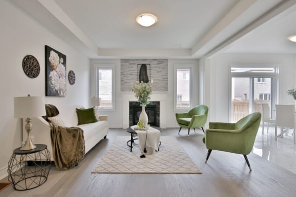 elegantes Wohnzimmer mit 2 grünen Sesseln und einem Kamin