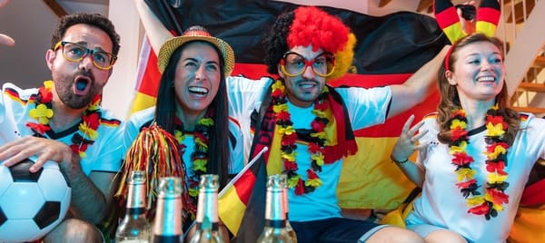 Fußballfans in Deutschlandfarben vor dem Fernseher