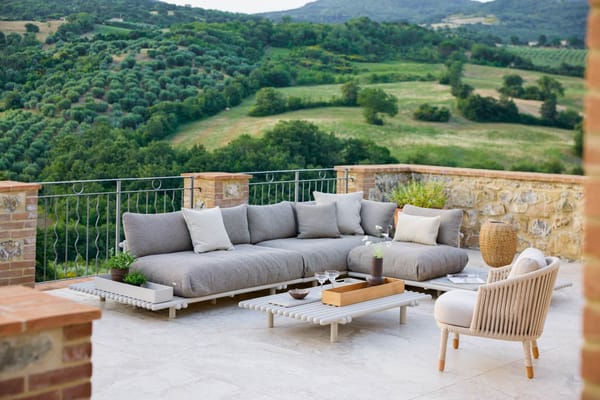 garden furniture trends, gray sofa in terrace overlooking the countryside