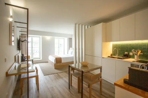 Stylish studio apartment with a bed, shelving and a small L-shaped kitchen